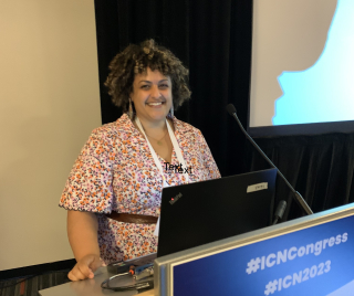 Jackie Girgis poses behind a podium at ICN Congress