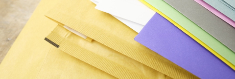 stack of yellow envelopes and coloured papers