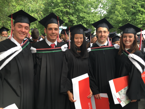 five students in caps and gowns on convocation day