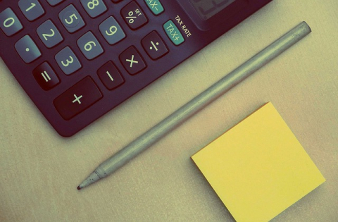 calculator, pen and Post-it note