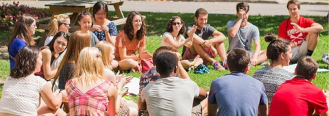 Students sitting in a circle on the grass 