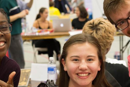 student smiling at the camera at an event