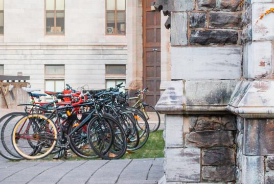 student walking by some bicycles 