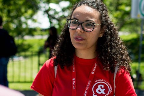 A McGill student volunteer, outside on a sunny summer day.