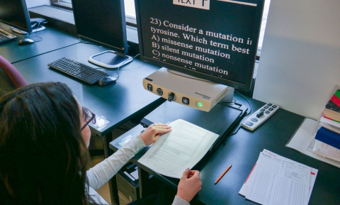 A student uses a screen enlarger to read a test at the Exam Center.