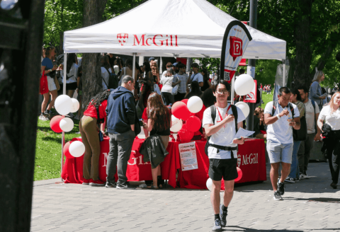 Students walk by a tent on lower campus during McGill orientation