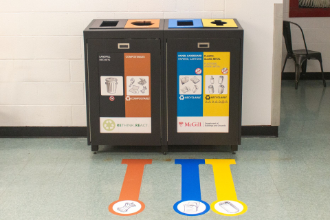 An image of waste bins with stickers indicating what to dispose of in each bin