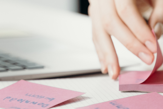person at a computer with post-it notes
