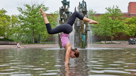Woman doing handstand yoga pose in water