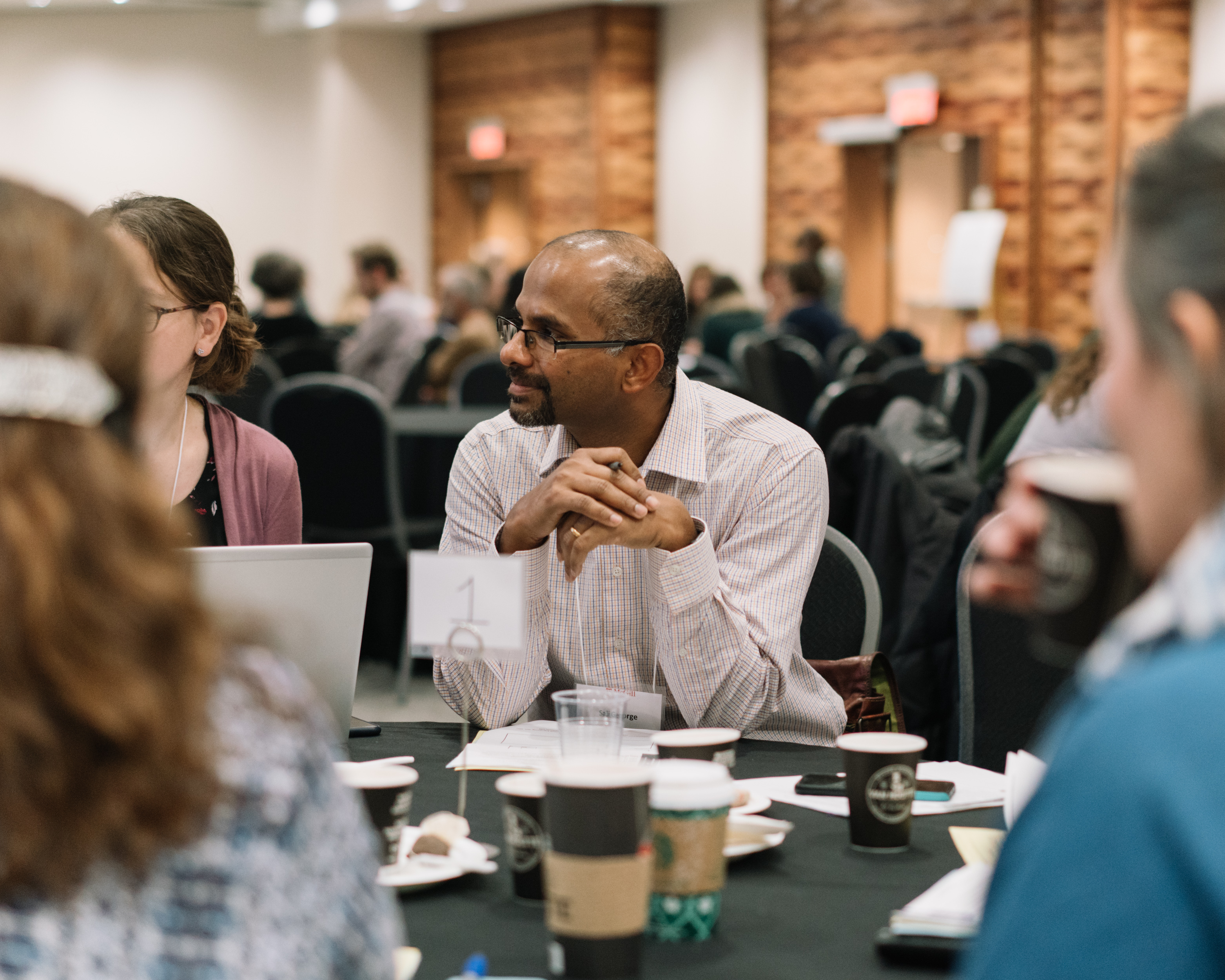 symposium participants sit around a table 