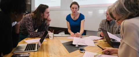 Instructors working around a table at the Course Design Workshop