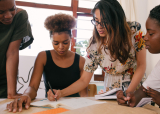 A group of people working together around a table