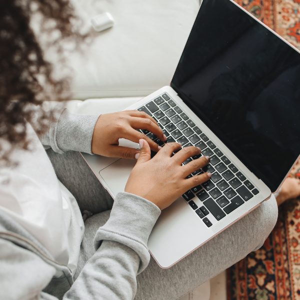 a person sitting with a laptop on their lap