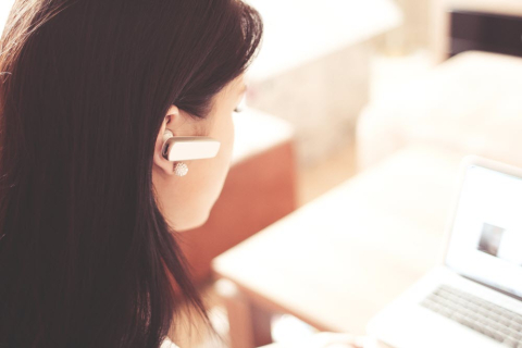 woman with earphone on computer 