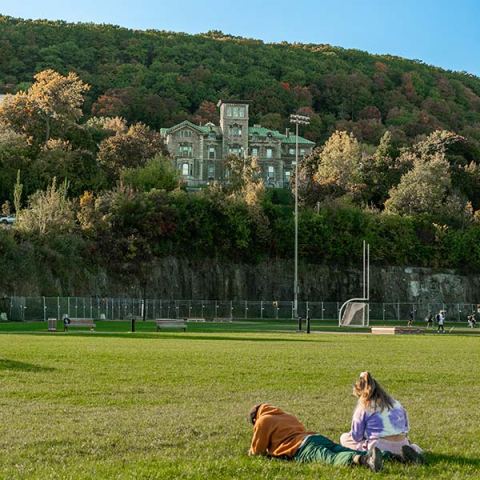 Students hang out on campus with Mont Royal in the background