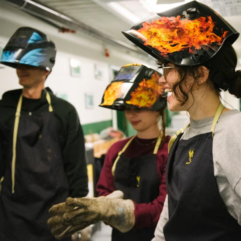 Students wear welding gear during an activity