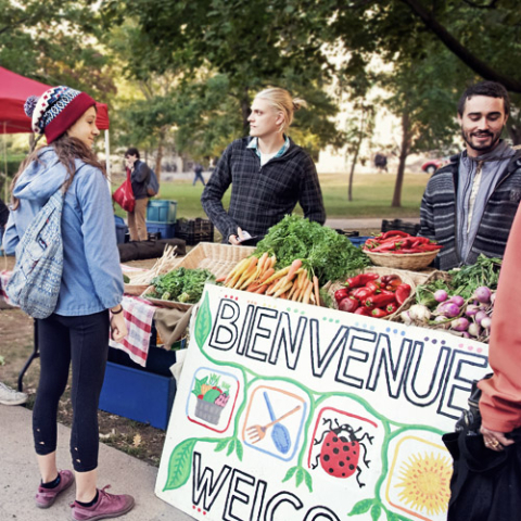 Photo d'étudiants vendant des fruits et légumes au marché fermier
