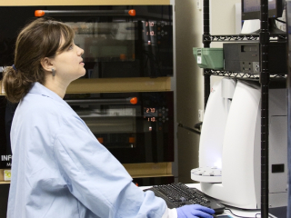 Scientist in lab coat working at a machine