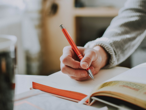 Image of hand writing in notebook