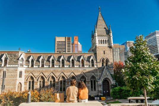 Two people sitting on a bench on McGill campus