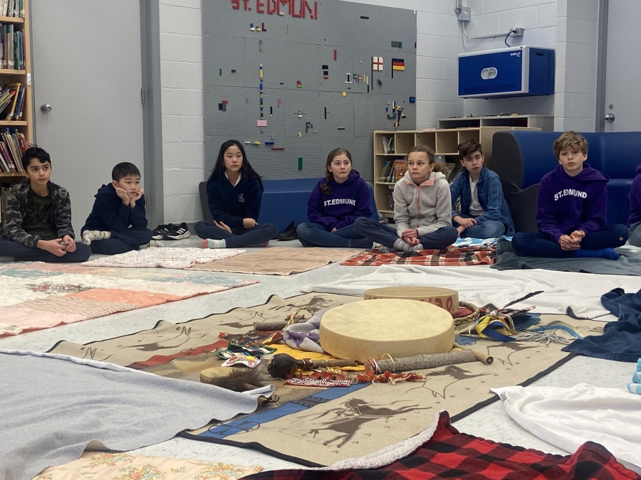 students sitting on floor with drums and blankets