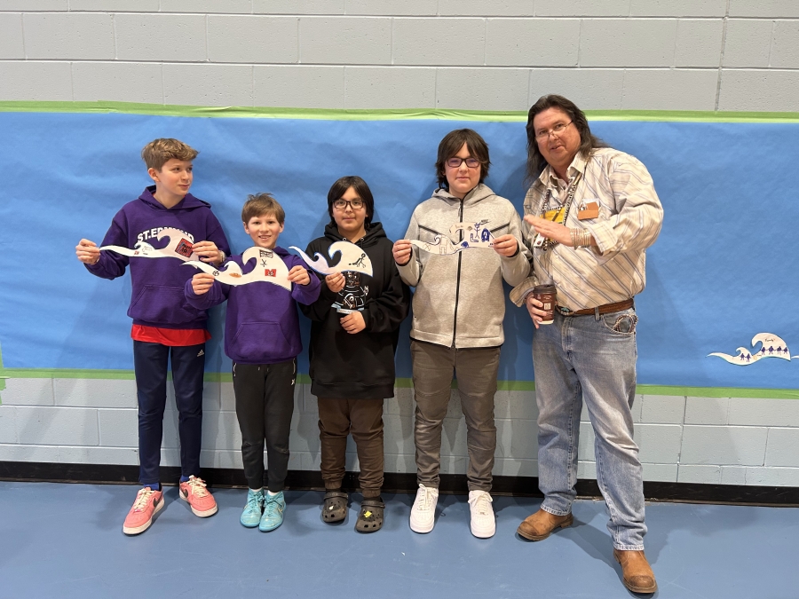 students and facilitators holding art