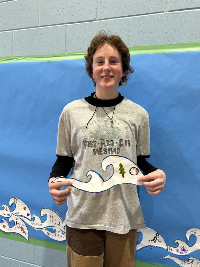 student smiling while holding wave