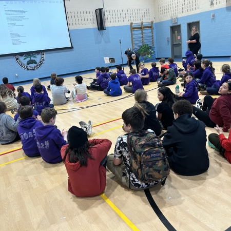 students sitting on the floor in the gym
