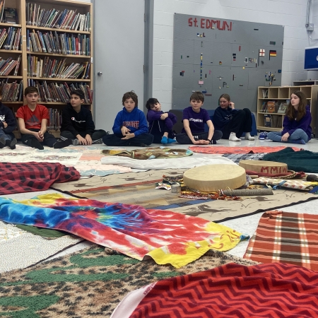 students sitting on floor with drums and blankets