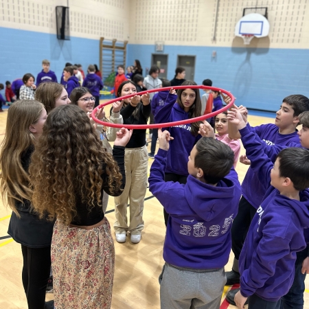 students in gym all holding hula hoop