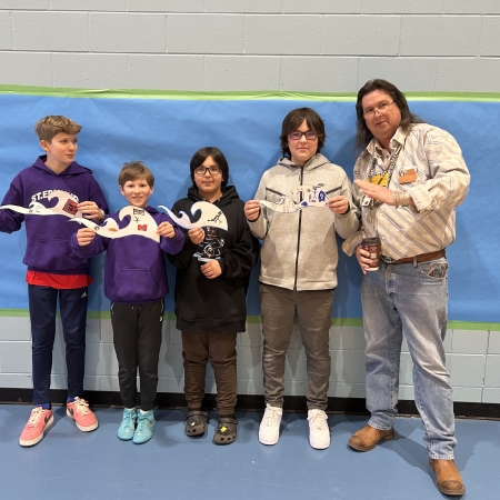 students and facilitators holding art