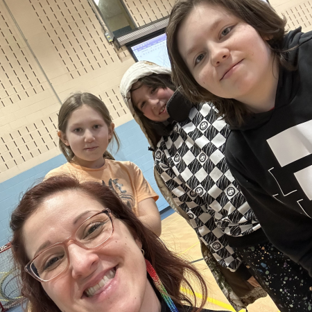 Facilitator posing with students for selfie
