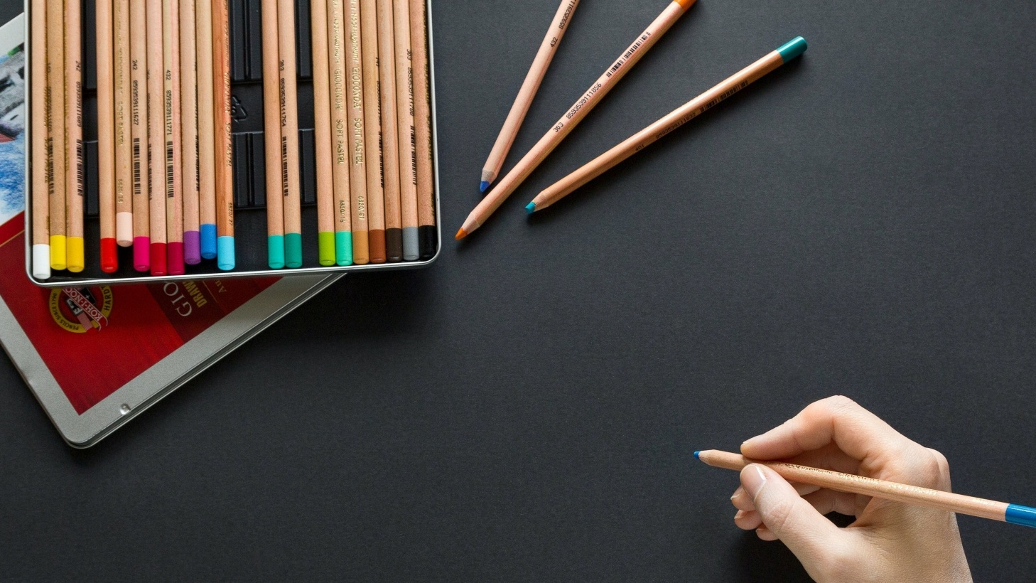 Person holding colored pencil