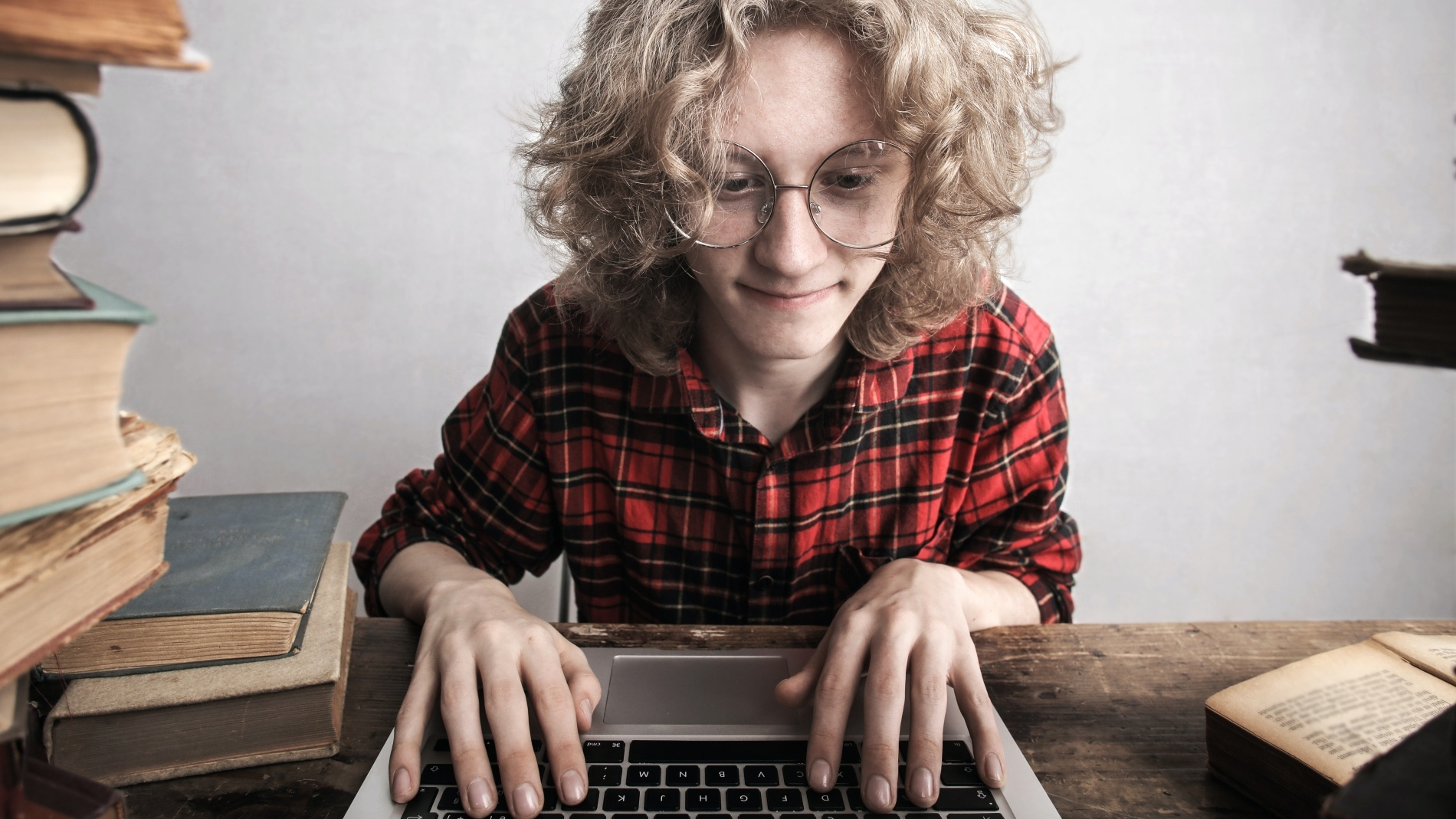 Young male student using laptop in library