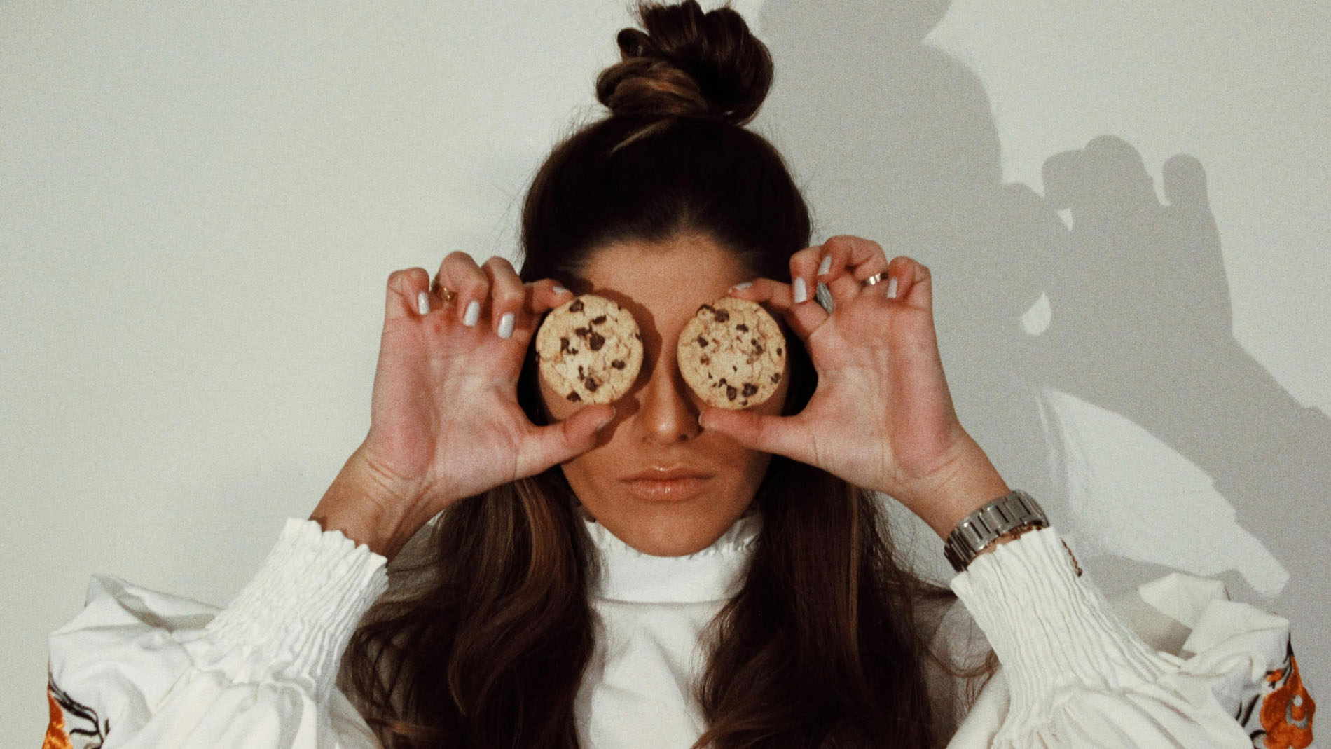 Woman holding cookies over her eyes