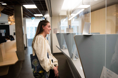 A student stands at the check-in counter at the Student Wellness Hub