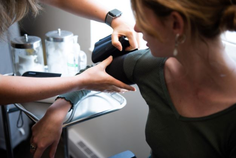 A healthcare provider puts a blood pressure cuff on a patient